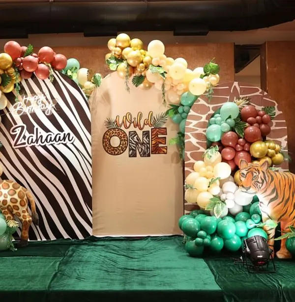 Let the wild rumpus start! This "Wild One" first birthday party features a stunning jungle theme with animal print backdrops, life-sized giraffe and tiger props, and lush green flooring.