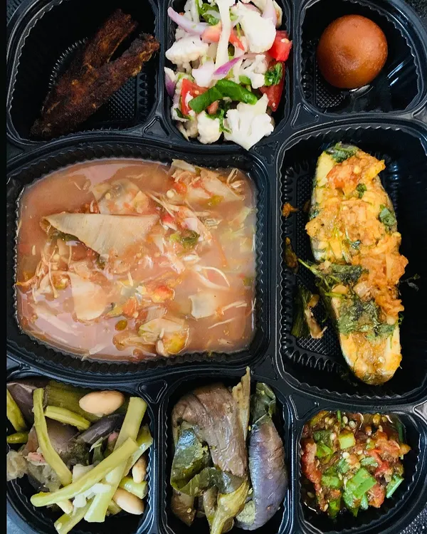 This is my special fish thali, packed and ready for you. It comes with steamed rice, fish cooked in a light gravy, a dry fish preparation, fresh salad, a vegetable side, and a sweet gulab jamun. A complete, delicious meal.