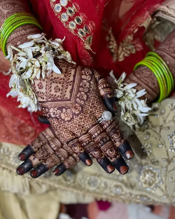 This is the stain goal for every bride. A close-up of the rich, dark color on the hands, adorned with fresh flowers and a beautiful ring. This is the result of my organic henna.