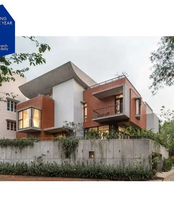 An exterior view of the Nairy Residence, which was nominated for the ArchDaily 2024 Building of the Year award. The composition balances heavy, protective forms with open, cantilevered balconies, expressing the home's layered approach to privacy and openness.