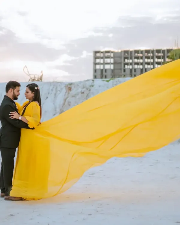 The vibrant yellow of this flying gown creates a stunning pop of color against the white landscape. I love creating these high-contrast, dramatic images that feel both artistic and romantic.