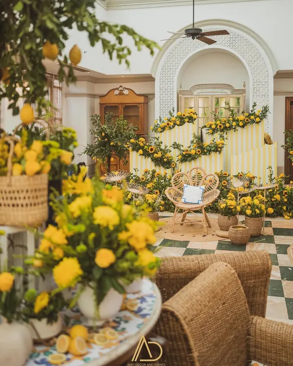 A vibrant and sunny Haldi setup, featuring a beautiful seating area surrounded by fresh sunflowers, lemon trees, and cheerful yellow decor.