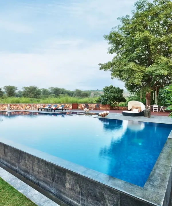 A tranquil infinity pool at our Aishbagh project, designed to merge seamlessly with the natural landscape of the Aravalli Hills. This space embodies our belief in creating serene retreats where architecture and nature exist in perfect harmony.