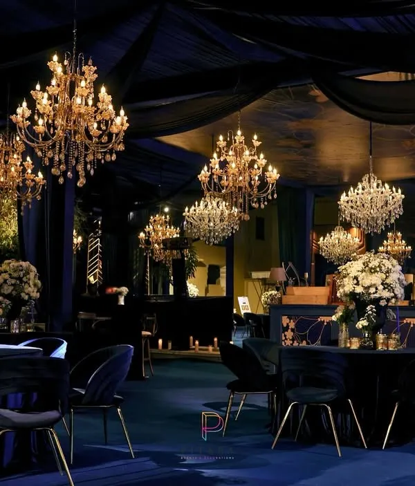 A reception that's giving modern royalty. We draped the space in midnight blue velvet, hung dozens of crystal chandeliers, and used white floral arrangements to create a dramatic, opulent atmosphere at Mundota Fort.