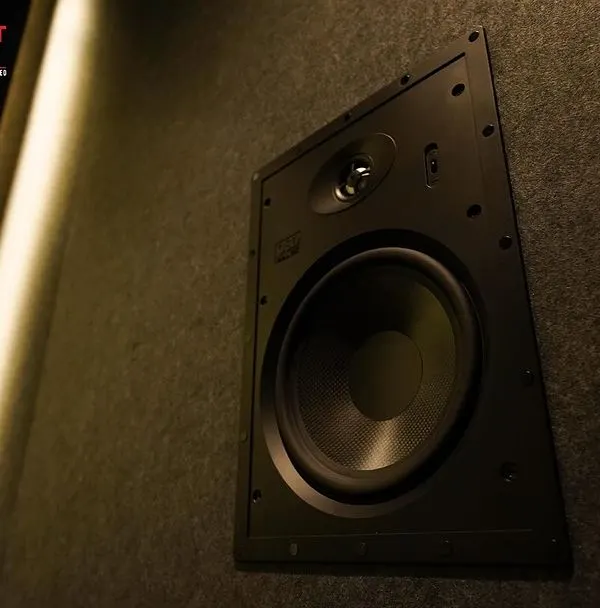 A close-up of an OSD Black T83 in-wall speaker, seamlessly integrated into the acoustic paneling of a luxury home cinema in Chennai.
