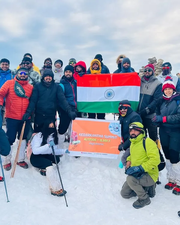 Summit day success. Our first Kedarkantha batch from Bengaluru celebrating their achievement at the top, surrounded by a sea of snow and mountains.