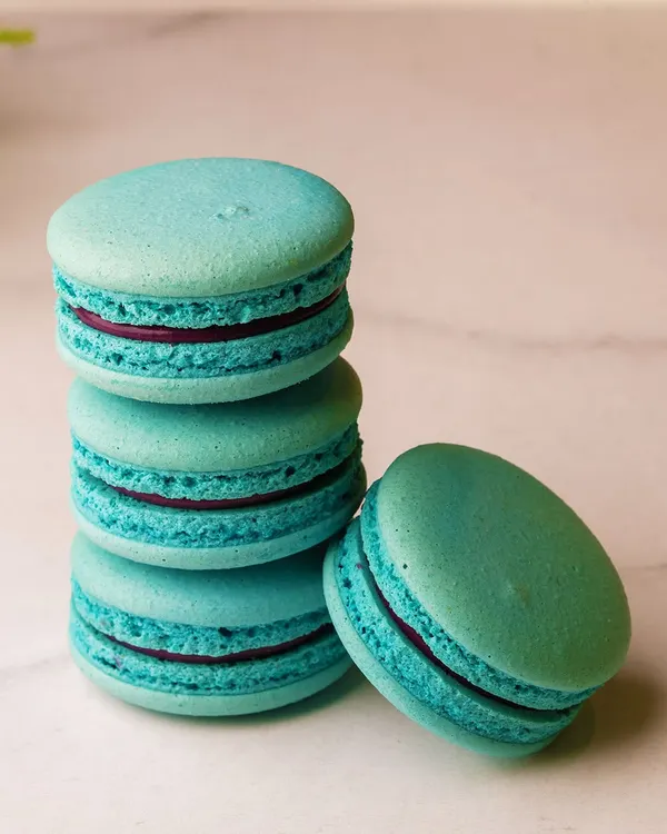 A stack of our beautiful turquoise macarons. Each one has a crisp shell, a chewy center, and is filled with a delicious ganache.