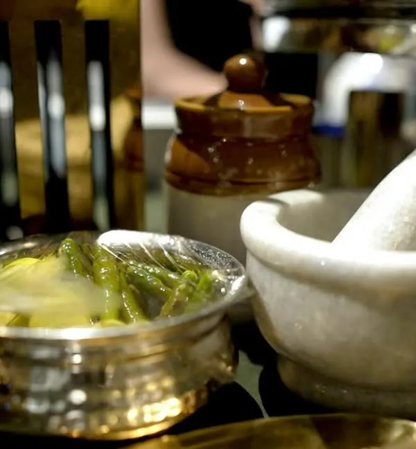 We use a mix of ethnic pottery and crystal marble serveware to enhance our food presentation. This small detail, featuring a traditional mortar and pestle, adds an authentic touch to the buffet.