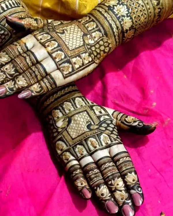 This engagement mehndi is for the bride who loves both peacocks and traditional Indian designs. The detailed grid work and bold motifs create a truly stunning look.