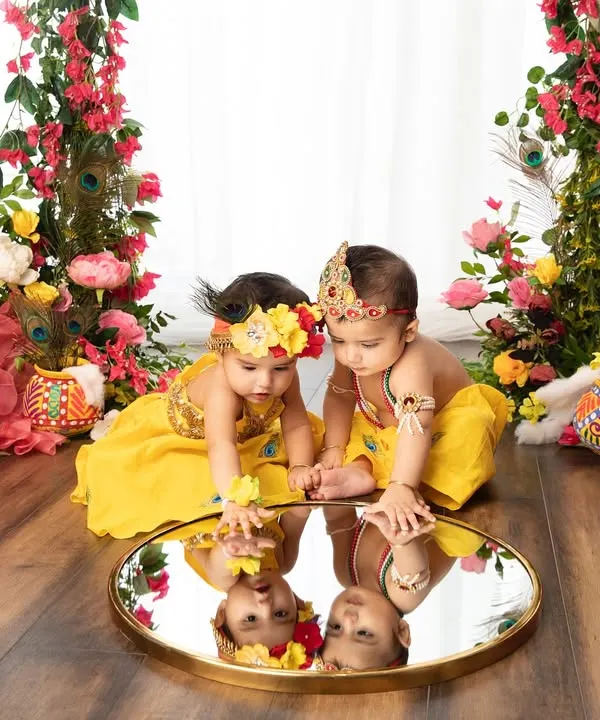 Double the divinity, double the fun. These two little ones, dressed as Radha and Krishna, share a moment of reflection in this beautifully styled Janmashtami setup.