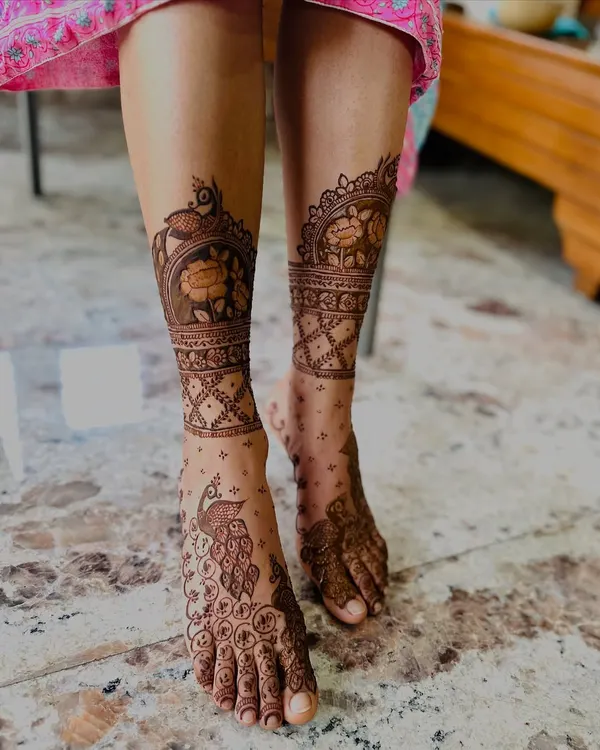 This foot design features majestic peacocks on the top of the feet and floral bands around the ankles. The detail is crisp and the composition is elegant.