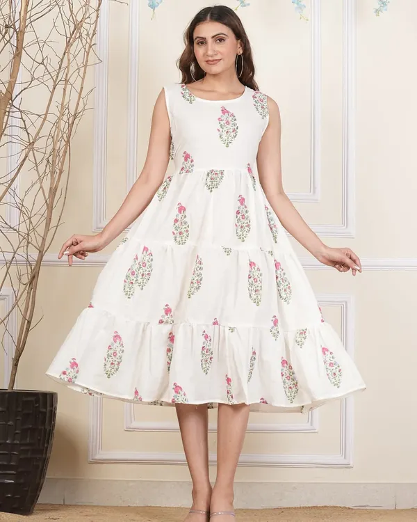 A beautiful white tiered cotton dress with delicate pink and green floral block prints. This sleeveless design is perfect for warm weather, offering a light and airy feel.
