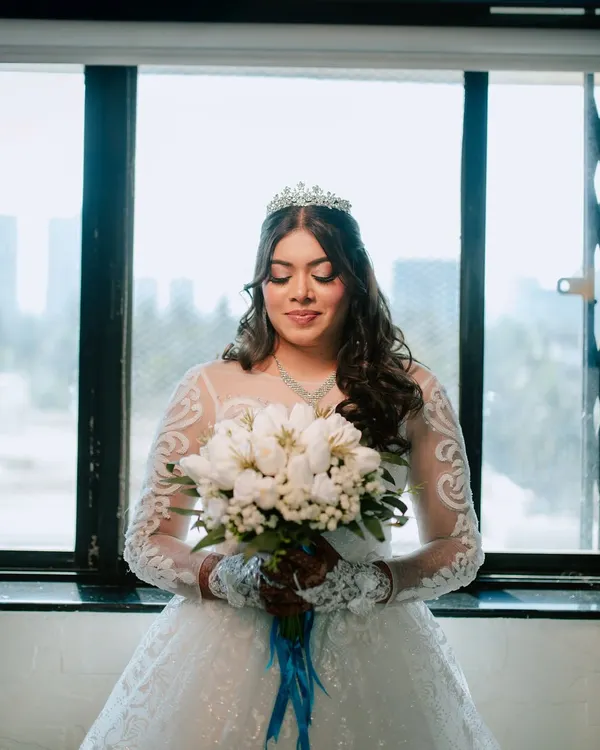 A serene portrait of the bride holding her bouquet just before the ceremony. I focus on capturing these quiet moments of anticipation and the beautiful details of the bridal look.