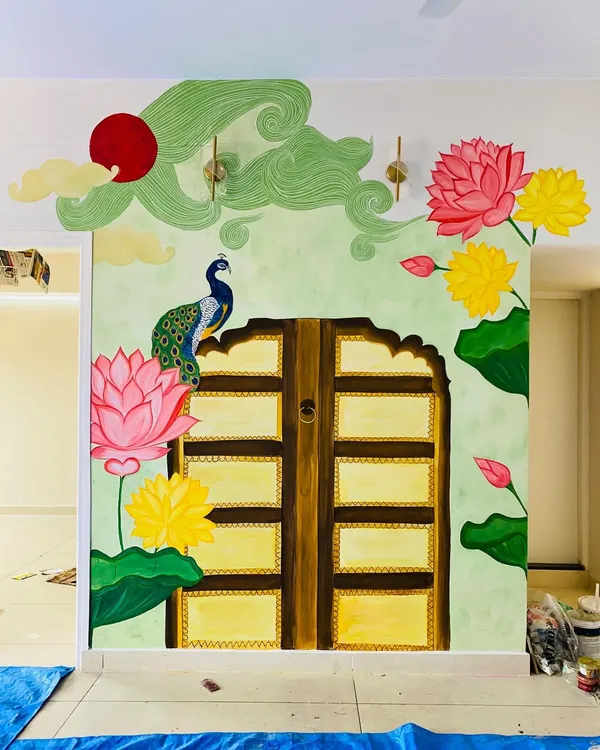 This traditional backdrop for a pooja mantap is one of our favorite projects. We worked closely with the client to bring together elements like the Jaipur-style door, vibrant Pichwai lotuses, and a proud peacock, creating a truly divine space.