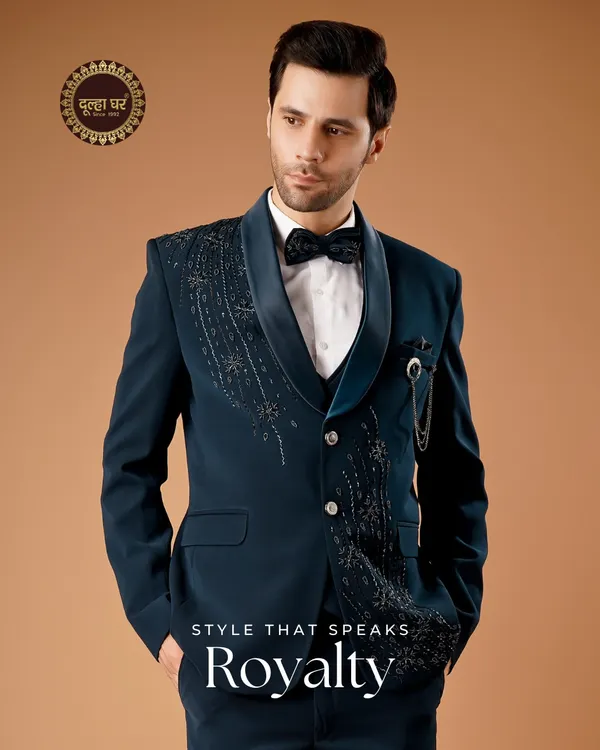 Style that speaks royalty. This deep teal tuxedo is designed for the modern groom's reception. The embellished lapel and sharp tailoring create a look that is both sophisticated and statement-making.