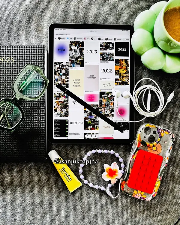 A New Year planning flatlay featuring my 2025 vision board on an iPad, a planner, chai, and other daily essentials. This is a great example of goal-oriented, motivational content.
