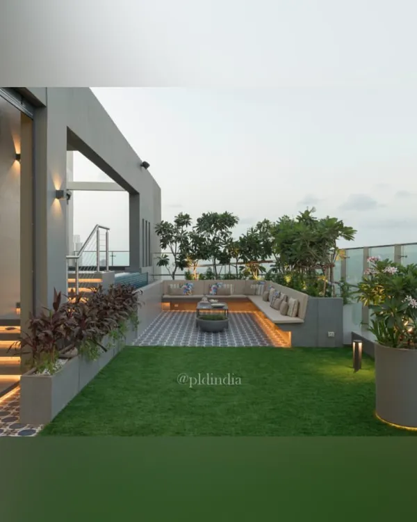This rooftop terrace in Mumbai is a slice of heaven on earth. We combined a soft lawn with patterned tile flooring and built-in seating, creating a multi-functional space for relaxing and entertaining, all framed by lush planters.