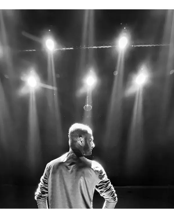 A high contrast, black and white shot of me on a stage, backlit by powerful spotlights. This frame is all about drama, mood, and the power of lighting in cinematography.