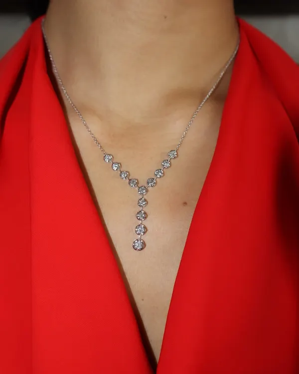 Let the neckline do the talking. This delicate Y-shaped diamond necklace features a cascade of round brilliant diamonds, designed to elongate the neck and add a touch of modern elegance.