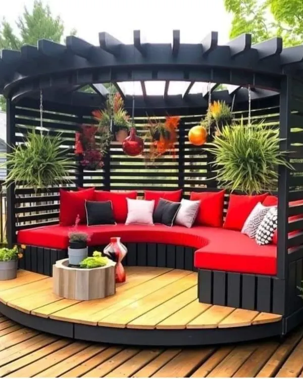 This circular pergola with built-in curved seating is a perfect example of our custom design capabilities. The vibrant red cushions add a pop of color to the dark wood structure, creating a stunning focal point.