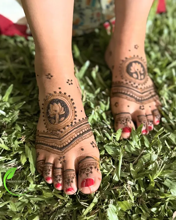 A simple and elegant foot mehendi design. This pattern features a central lotus motif with delicate lines extending to the toes, perfect for any occasion.