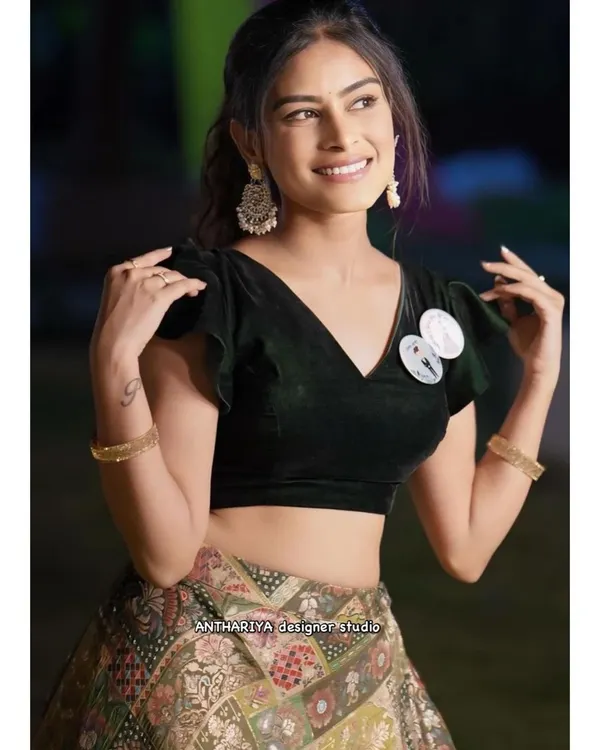 A close-up of a simple yet elegant black velvet blouse with flutter sleeves, paired with a modern printed lehenga skirt.