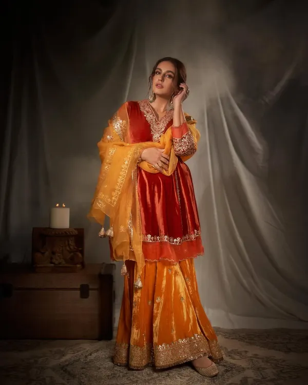 This look captures pure festive opulence. I chose a rich, jewel-toned velvet sharara set in shades of orange and red, accessorized with regal gold jewelry to create a look that is both traditional and incredibly glamorous.
