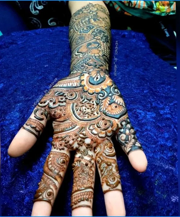 A close-up shot of a single palm, showcasing the incredible detail in the finger work and the central patterns. The use of light and dark shading adds depth to the design.