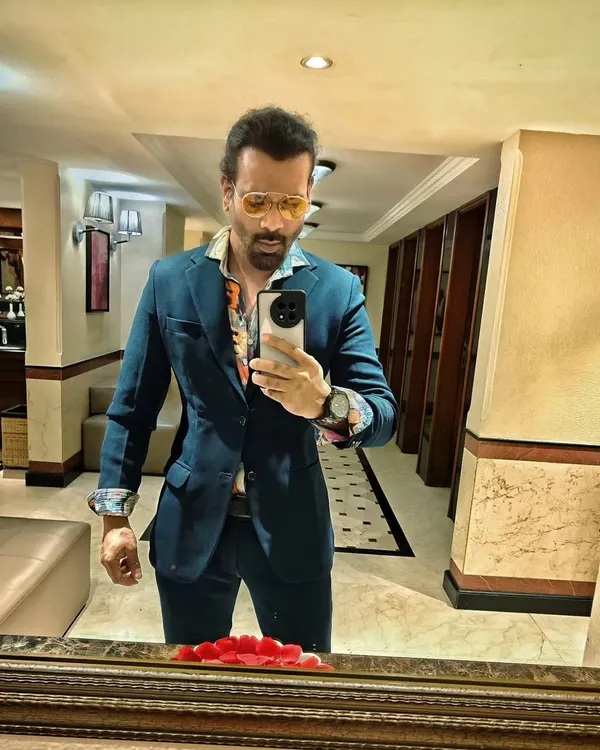 A quick selfie before a gig. I'm wearing a stylish blazer over a floral shirt, a look that's perfect for an upscale cocktail party.