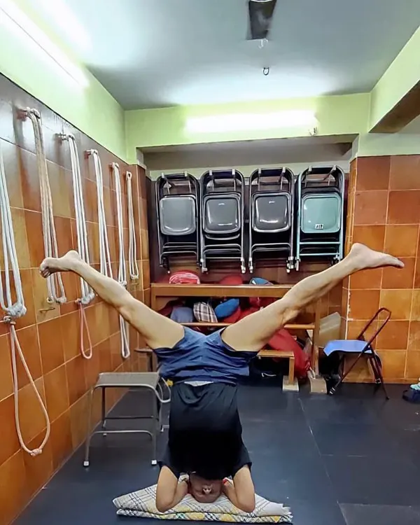 A variation of Sirsasana (Headstand) with legs in Upavistha Konasana. This advanced inversion requires significant core strength, balance, and concentration.