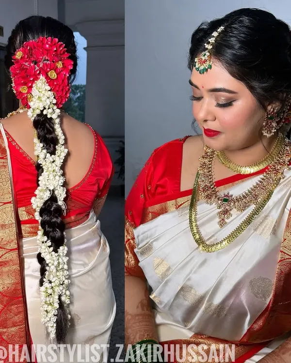 This is my signature South Indian bridal hairstyle. I created a traditional thick braid and meticulously adorned it with fragrant jasmine and vibrant red flowers, crafting a classic and timeless look for the main wedding ceremony.