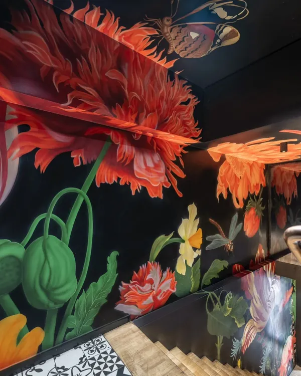 This hand-painted floral mural transforms a restaurant staircase into an immersive journey. Each step invites you deeper into a blooming world, setting a dramatic and enchanting mood before the dining experience even begins.