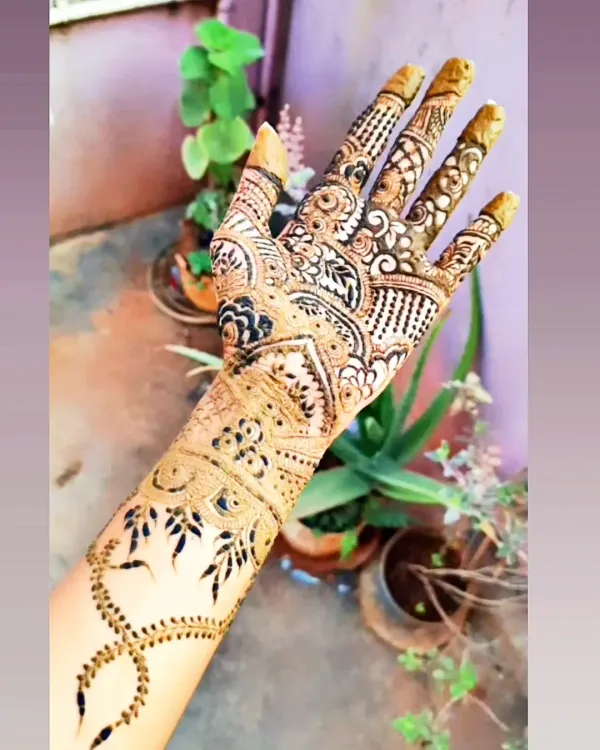 This is a great example of a heavy party mehendi design. The entire hand is filled with a variety of patterns, including checks, florals, and paisleys, for a rich and traditional look.