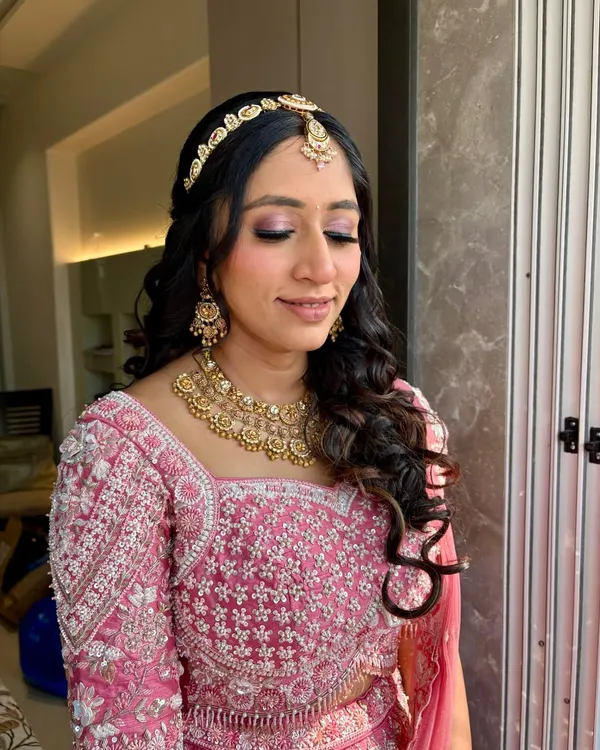 A beautiful pink glam look. The makeup features a shimmery pink eyeshadow and a flawless base, perfect for any festive occasion.