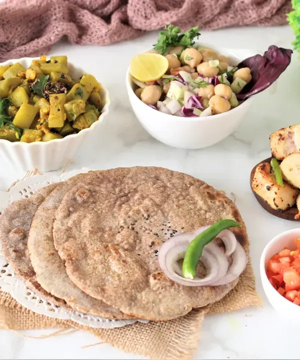This is a typical vegetarian meal, featuring multigrain bhakri, a seasonal vegetable preparation, high-protein paneer, and a fresh chickpea salad. It’s a complete, balanced office lunch that provides sustained energy.