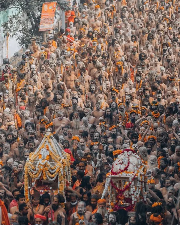 A ground-level photograph of the Naga Sadhus at the Kumbh Mela in Haridwar. This is not an aerial shot, but a close, respectful portrait of their procession, capturing the intensity and spiritual power of these ascetics.