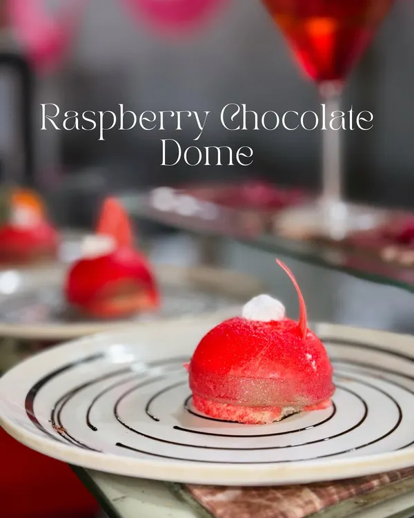 This is my Raspberry Chocolate Dome, a dessert that's as beautiful as it is delicious. It features a soft sponge base, a rich Nutella chocolate mousse center, and a vibrant raspberry coating for a perfect balance of flavours.