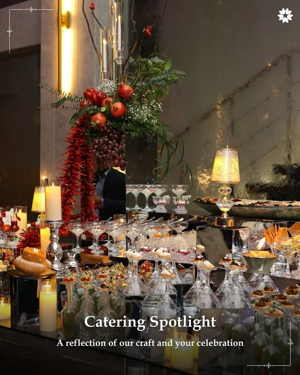 A magnificent grazing table set for an evening celebration. The display is a tapestry of colours and textures, with candles, fresh fruit, and an abundance of gourmet bites creating an atmosphere of luxurious indulgence.