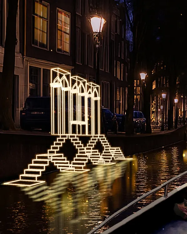 A close-up of the "Echoes of the Deep" light installation in Amsterdam. The glowing lines form an abstract representation of an Indian step-well, creating a piece of architecture made purely of light that interacts with its reflection in the canal water.