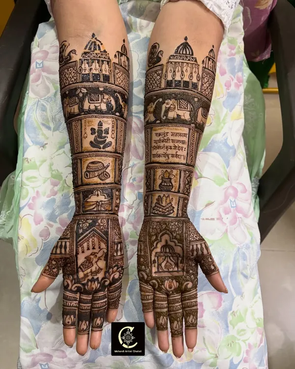 This is a close up of a highly detailed bridal design. It features intricate architectural elements inspired by temples, a figure of Ganpati for blessings, and even a Sanskrit shloka for a truly personalized touch.