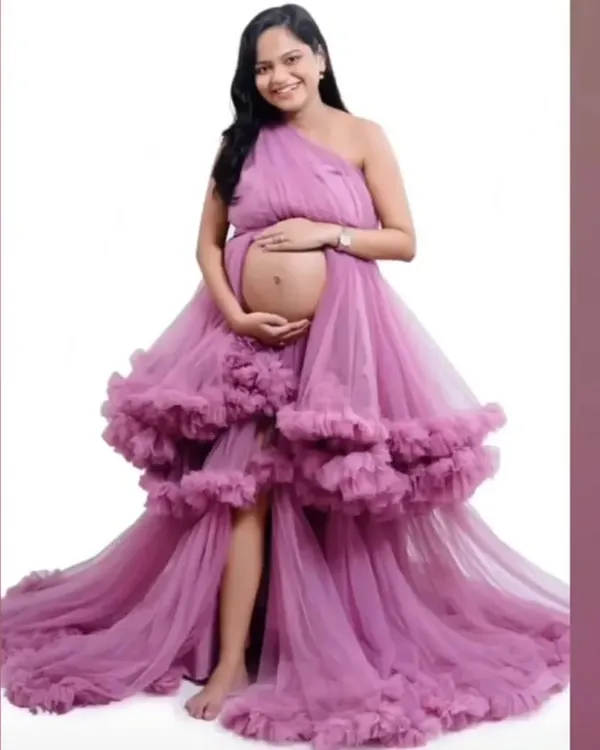 This pink ruffle gown is one of our most popular maternity styles. It's made from a soft, lightweight net but gives a heavy, luxurious look, and features a thigh-high slit.