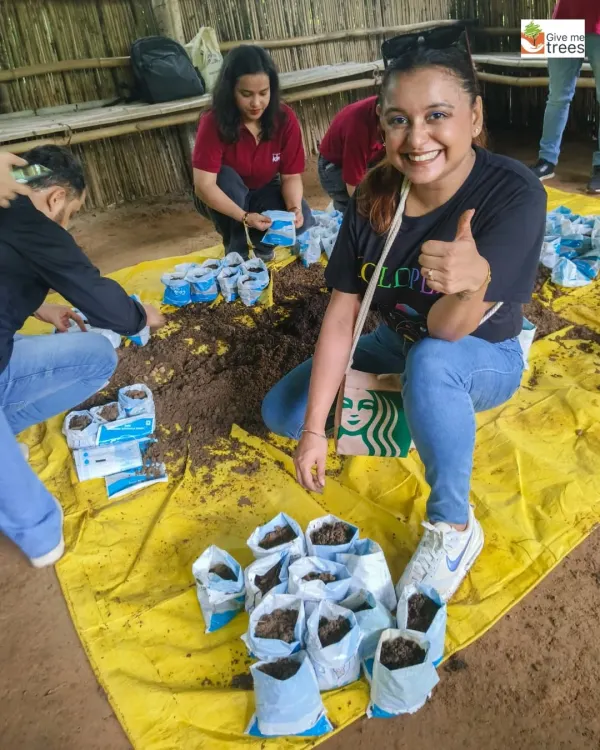 A volunteer from KPMG gives a thumbs-up during a stem cutting activity. Our workshops are hands-on, teaching skills that participants can use in their own homes and communities.