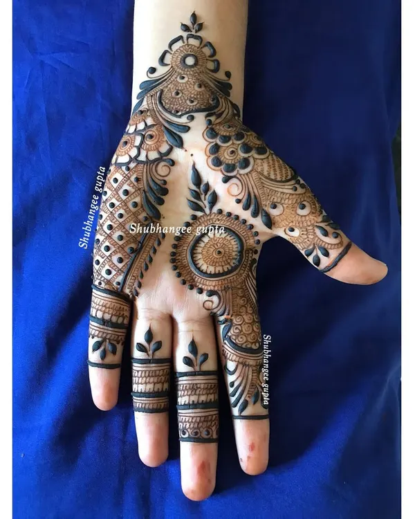 A beautiful and modern designer mehndi piece. This style uses a mix of bold strokes, delicate vines, and a central mandala to create a flowing design that is both traditional and contemporary.