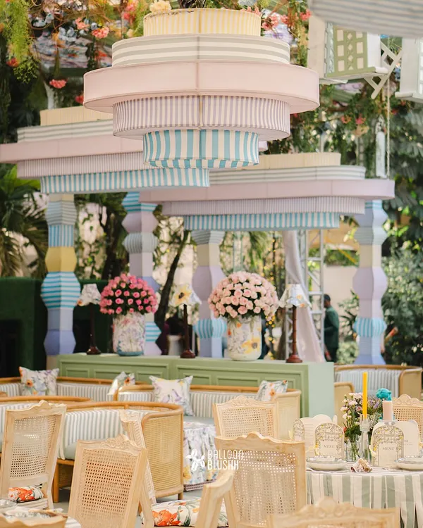 This image showcases our ability to create large, impactful structures that define a space. This custom-built pastel-striped canopy and pillar installation became the architectural heart of this whimsical garden-themed event.