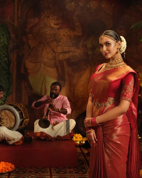 A solo shot from the Pothys Sarees campaign. The rich red Kanchipuram silk is draped to perfection, highlighting the model's regal posture and the saree's luxurious texture.