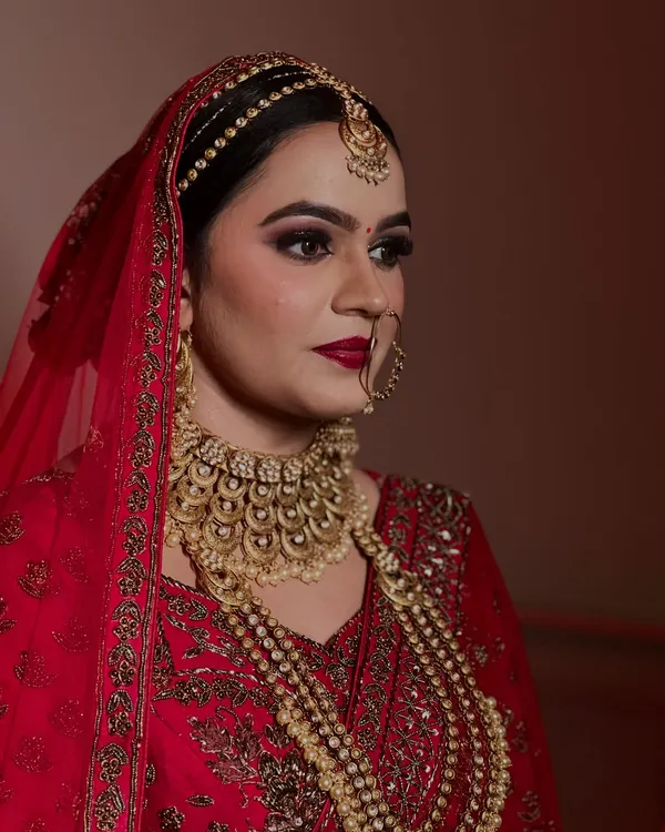 A close up of a regal bride. The focus here was on creating a bold, classic red lip and dramatic smokey eyes to match her magnificent gold jewelry.