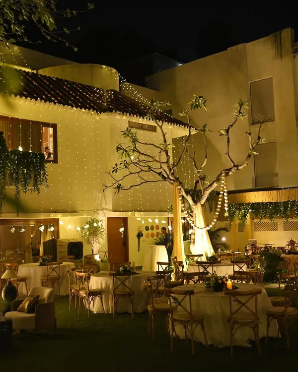 A wide shot of a stunning backyard transformation for a housewarming. We used elegant table settings, cozy lounge areas, and an abundance of fairy lights to create a truly magical garden party atmosphere.