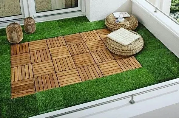 I love combining materials for a custom look. This balcony floor features a central 'rug' of wooden deck tiles surrounded by a border of soft artificial grass, offering the best of both worlds.