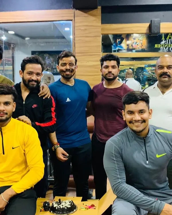 The whole crew comes together to celebrate. This is what our gym family looks like, sharing smiles and cake after a good workout session.