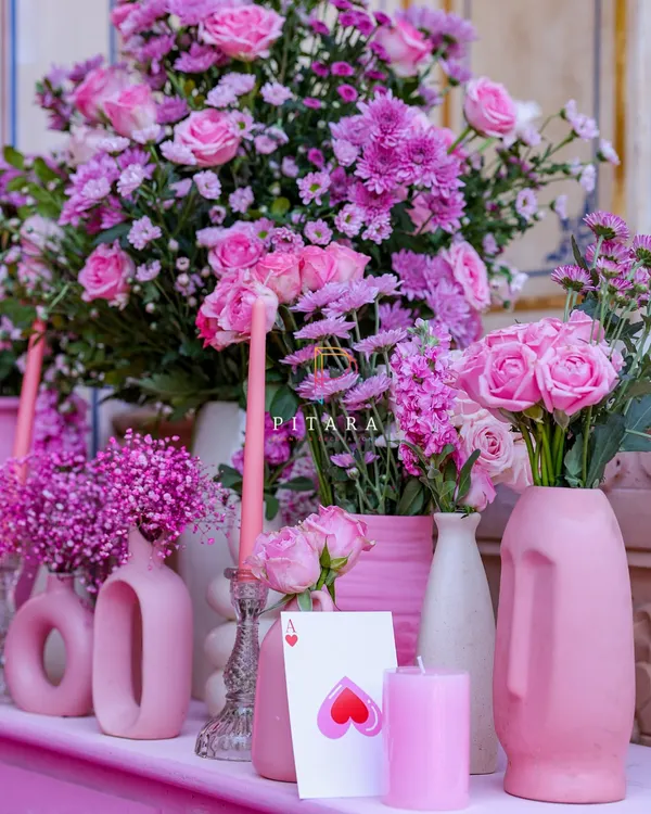 A console table that's a whole mood. I layered different shades of pink using modern, sculptural vases, taper candles, and an abundance of chrysanthemums and roses. It’s decor that’s confident and knows it looks good.